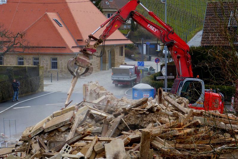 red excavator machine removing debris of a demolition